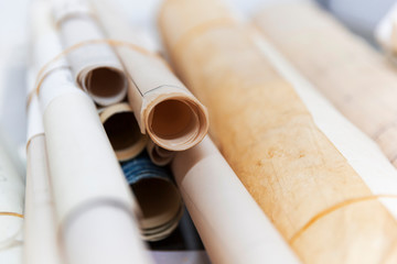Large blue print scrolls bound together by elastic bands.