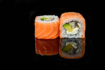 traditional fresh japanese sushi rolls on a black background