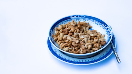 Peanuts in porcelain plates on a white background