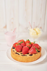 Strawberry cake and dessert on a white wooden background.