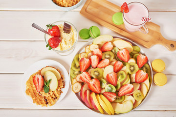 Vegetarian sliced ​​fruit. Strawberries, kiwi, bananas, apples are sliced. Raw food and healthy food.