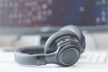 Obraz na płótnie Canvas macro wireless bluetooth over-the-ear headphones on computer keyboard
