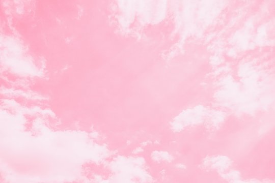 Light delicate pink sky background. Beautiful romantic sky with white clouds.Copy space, toned photo