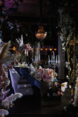 a wedding hall decorated with flowers and a chic chandelier hanging from the ceiling