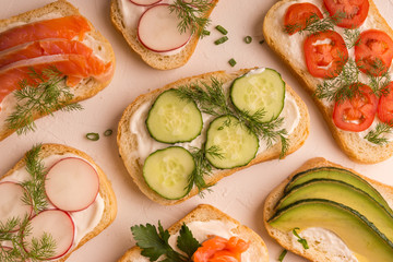 Sandwiches with salmon, cucumber, tomatoes, avocados and greens, vegetable sliced