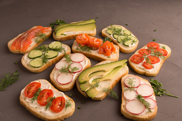 Sandwiches with salmon, cucumber, tomatoes, avocados and greens, vegetable sliced