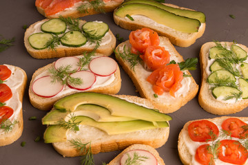 Sandwiches with salmon, cucumber, tomatoes, avocados and greens, vegetable sliced