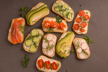 Sandwiches with salmon, cucumber, tomatoes, avocados and greens, vegetable sliced