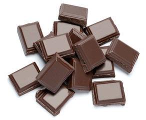 Dark organic chocolate pieces isolated on white background