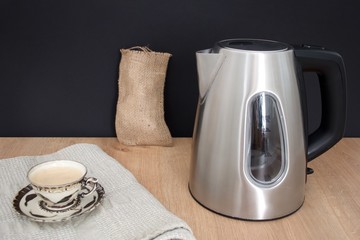 Metal mug and cup of coffee on the wooden table