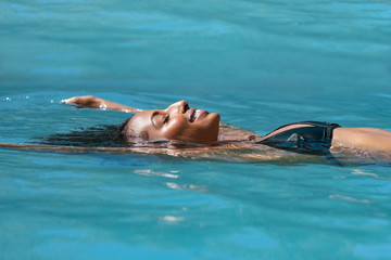 Relaxed woman floating in swimming pool