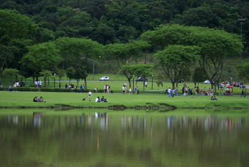 People at the park relaxing by the side of a lake