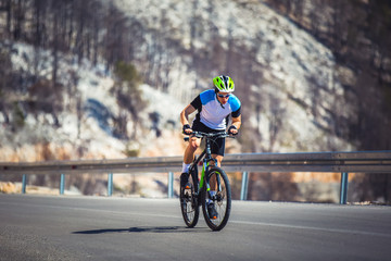 Naklejka premium Man ride mountain bike on the road. Sport and active life concept.