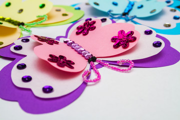 Application made with hot melt glue gun. Three butterflies made of colored paper, multi-colored...