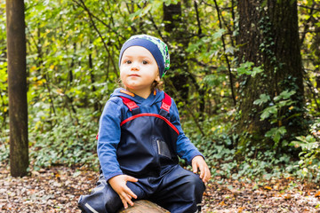 baby playing on a forest path in autumn