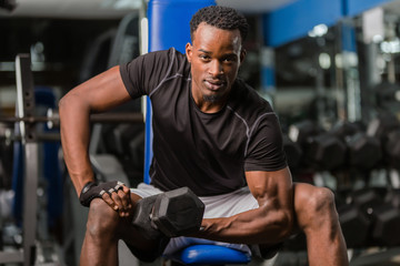 Fototapeta na wymiar Black African American young man doing workout at the gym