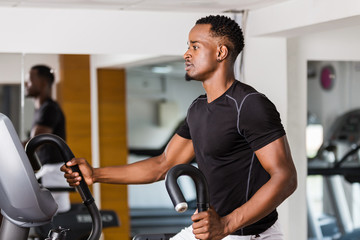 Fototapeta na wymiar Black African American young man doing cardio workout at the gym