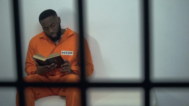 African-american prisoner reading holy bible, convicted sinner, religion