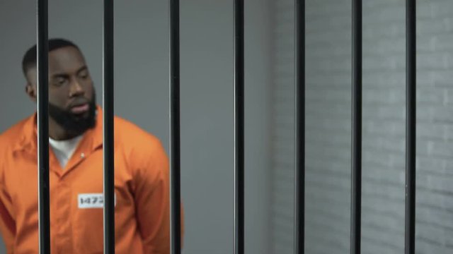 Afro-american prisoner making arrangement with prison guard, corruption in jail
