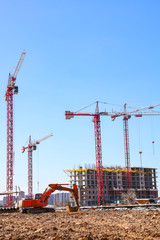 Construction of multi-storey buildings near Moscow. Construction cranes on the construction site. Sunny day.
