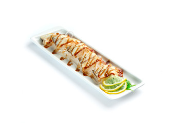 pieces of white fish with lemon and herbs on a rectangular plate on an isolated white background