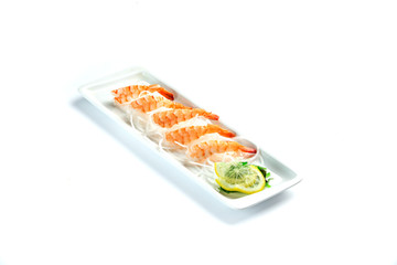 shrimps with lemon on a rectangular plate on an isolated white background