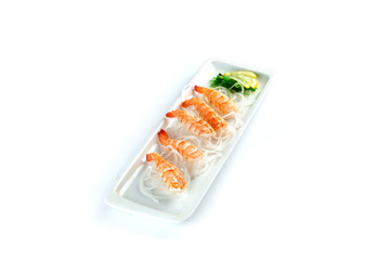 shrimps with lemon on a rectangular plate on an isolated white background