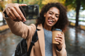 Beautiful young african woman wearing coat walking outdoors