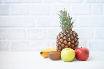 Diet weight loss breakfast concept with tape measure organic apple, orange, kiwi, grapefruit, bananas on a white background 