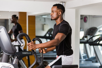 Black African American  young man doing cardio workout at the gym