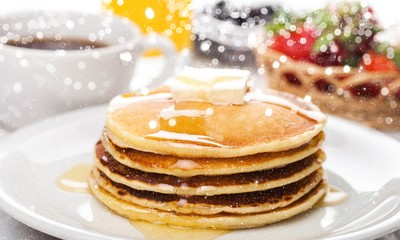 Stack of Small pancakes in syrup on background