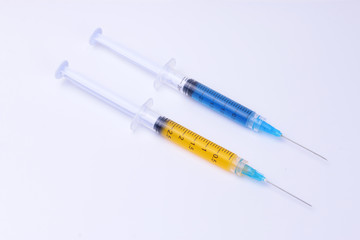 Syringes. Syringes with yellow and blue liquid inside.