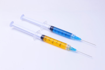 Syringes. Syringes with yellow and blue liquid inside.