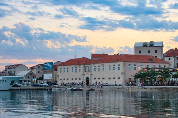 Fototapeta na wymiar View from the water on old town of Bol on island Brac, Croatia. Cloud sunset sky and mountains in background
