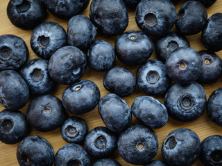 Natural looking blueberries on wooden background. Selective focus.
