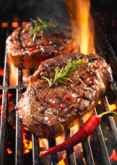 Beef steaks sizzling on the grill