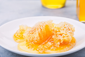 Honey background. Sweet honey in the comb, glass jar.
