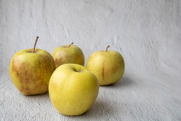 ugly food Four apples, one beautiful one and three spotted on a grey concrete background