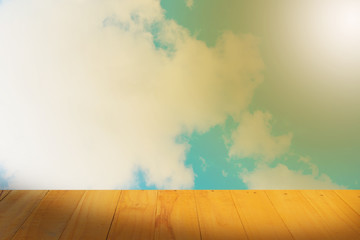 Old Wooden table with blue sky white cloud background.
