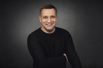 smiling man in casual black sweater