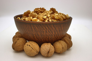 Walnut Kernels In Clay Bowl (Other Names: Juglans Regia, Persian Walnut, English Walnut, Circassian Walnut). Isolated Image On A White Background