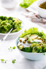 Vegetarian green salad with avocado, peas, broccoli and microgreen. Healthy food.