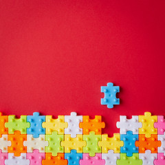 Colors plastic jigsaw puzzle on red paper background, Missing one jigsaw puzzle to complete with copy space. - 260278557