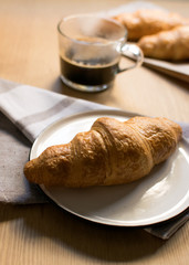 coffee and french croissants on wooden background