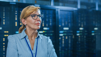 Portrait of a Beautiful Senior Female IT Technician Standing In Modern Data Center. In the...