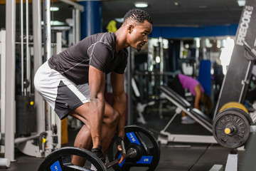 Naklejka na ściany i meble Black African American young man doing workout at the gym