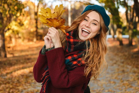 Cheerful young girl with long brown hair wearing autumn