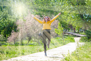 Fototapeta na wymiar happy woman hopping in the park celebrating her success
