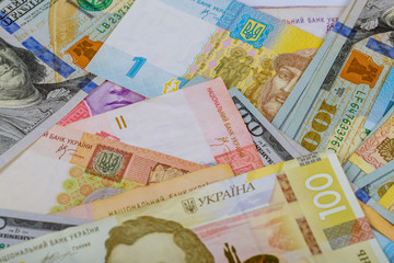 US dollars and ukrainian hryvnia, banknotes background.