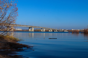 Fototapeta premium Autumn day in Arkhangelsk. View of the river Northern Dvina and automobile bridge in Arkhangelsk.